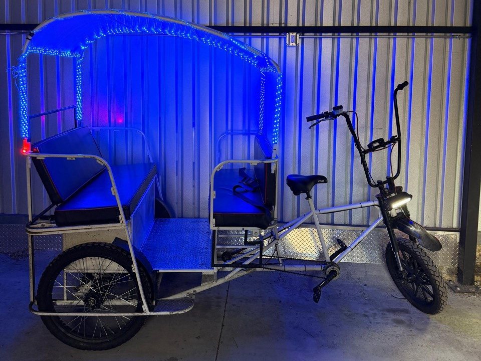 Ex-fleet VIP pedicab with blue LED canopy lights in the San Diego shop
