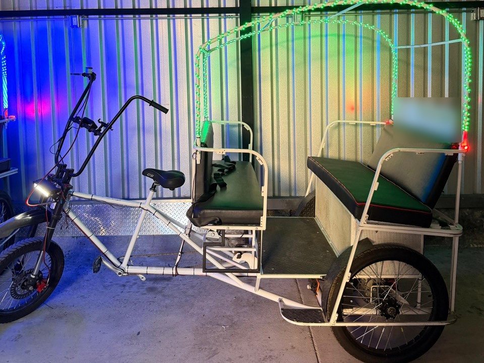 Ex-fleet VIP pedicab with green LED canopy lights in the San Diego shop